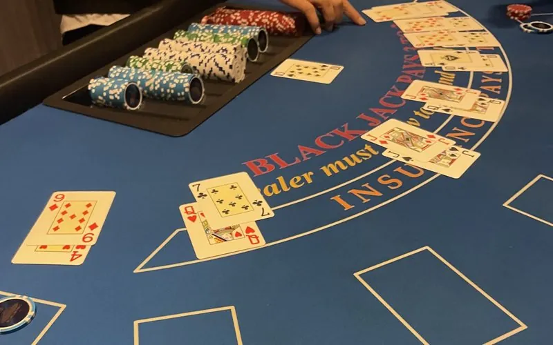 Blackjack table with dealt cards and the dealer's chip tray