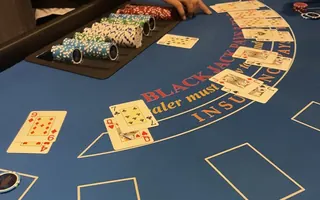 Blackjack table with dealt cards and the dealer's chip tray